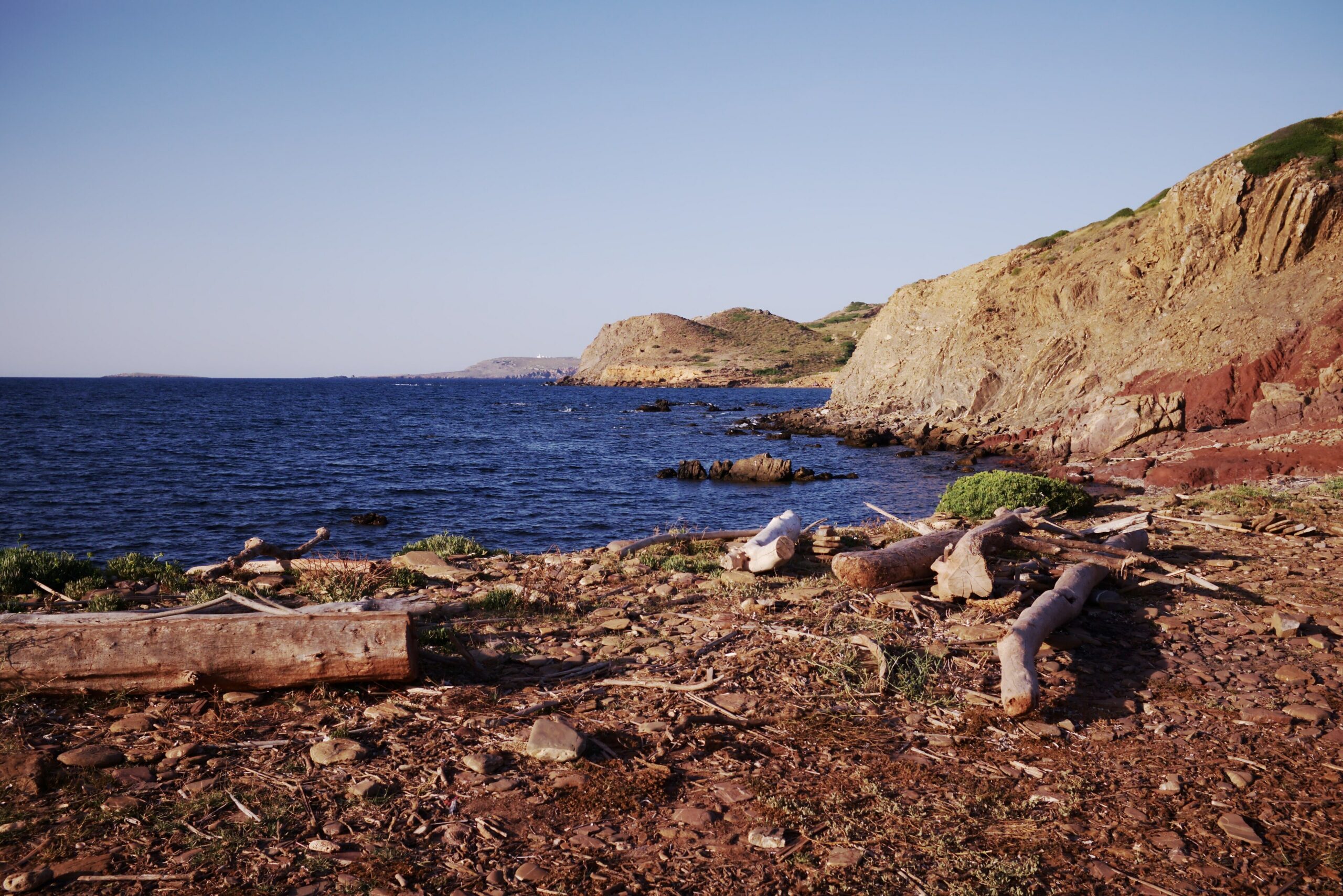 Acantilados rojizos sobre el mar en la costa norte de Menorca