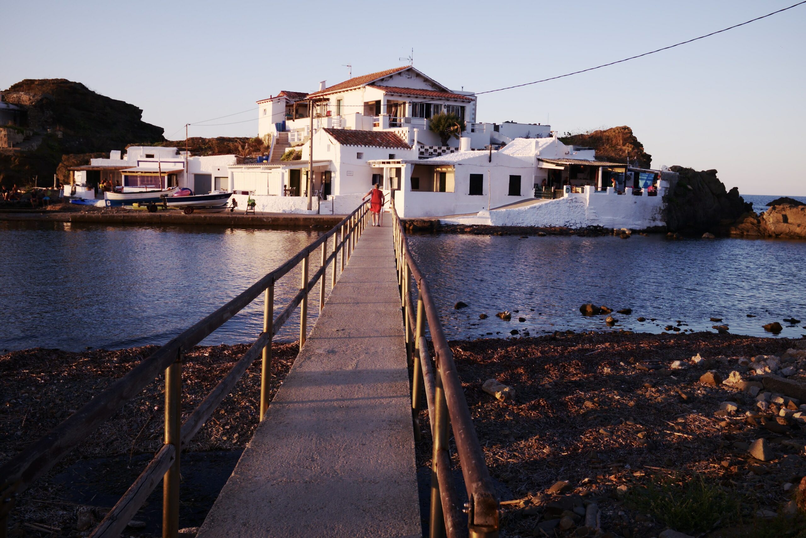 Casas blancas junto al mar en la costa de Menorca al atardecer